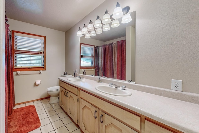 full bathroom with double vanity, toilet, a sink, and tile patterned floors