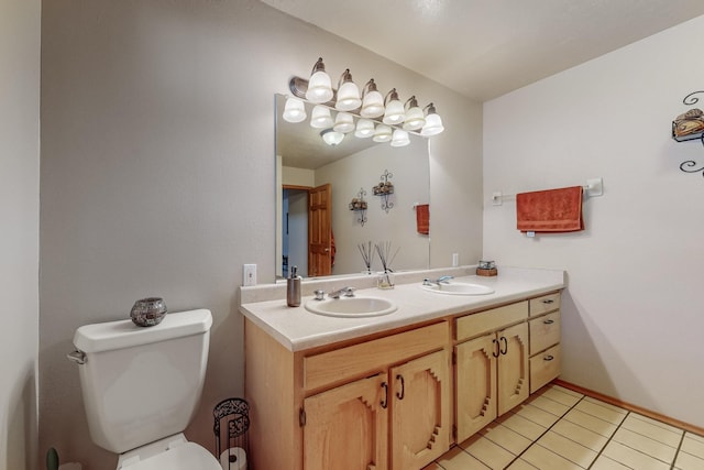 bathroom featuring tile patterned floors, a sink, toilet, and double vanity