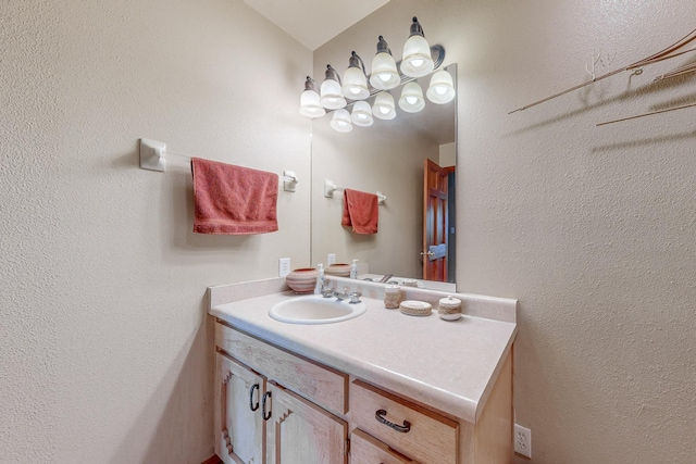 bathroom with a textured wall and vanity