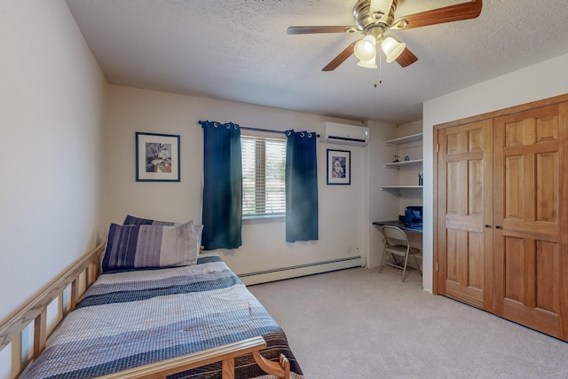 carpeted bedroom featuring a baseboard radiator, a wall unit AC, ceiling fan, and a textured ceiling