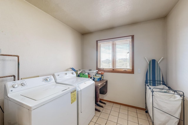 laundry room featuring laundry area, baseboards, washing machine and clothes dryer, and light tile patterned floors