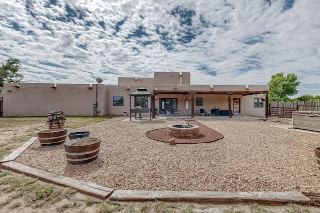 back of house with a fire pit, a patio area, fence, and stucco siding