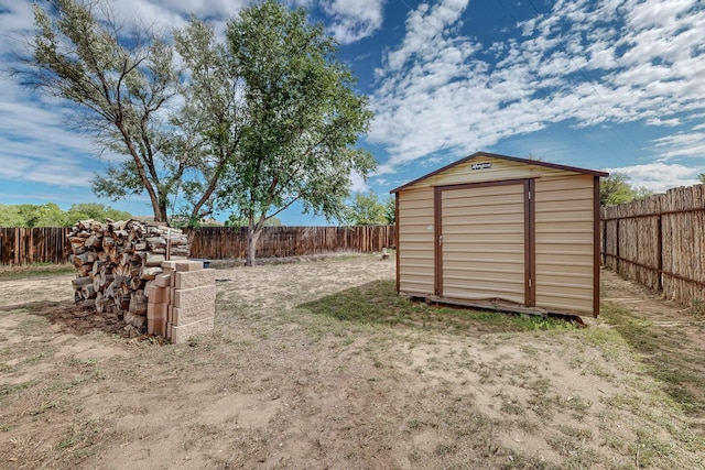 view of yard with a shed, a fenced backyard, and an outbuilding