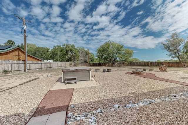 view of yard with a fire pit, a patio, a fenced backyard, and a hot tub