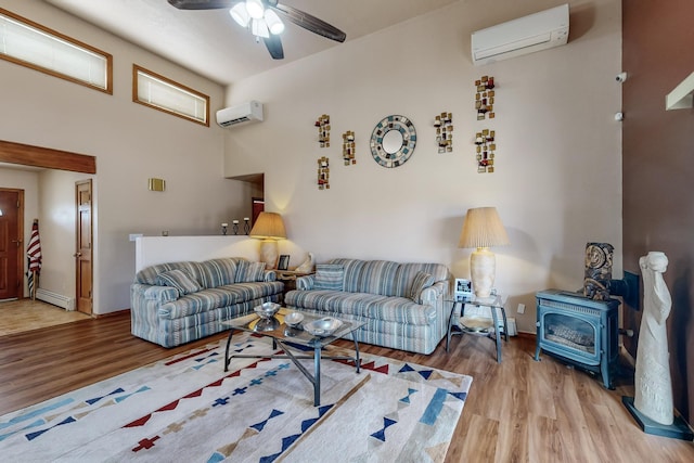 living room with an AC wall unit, a baseboard radiator, wood finished floors, and a wood stove