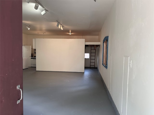 spare room featuring rail lighting and concrete floors