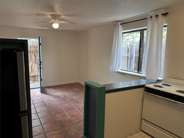 kitchen featuring refrigerator, tile patterned floors, white electric range, a textured ceiling, and ceiling fan