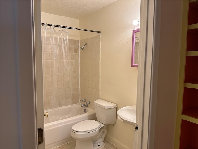 bathroom featuring a textured ceiling, toilet, a sink, tile patterned floors, and shower / bath combo with shower curtain