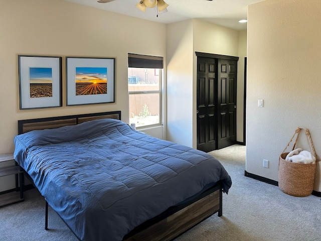 carpeted bedroom featuring a closet and ceiling fan