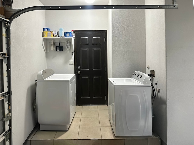 clothes washing area with light tile patterned floors and independent washer and dryer