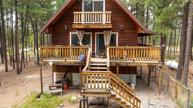 rear view of property with a balcony and a wooden deck