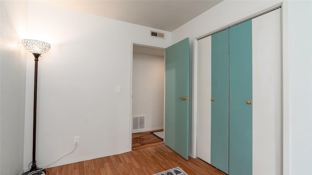 unfurnished bedroom with hardwood / wood-style floors and a closet