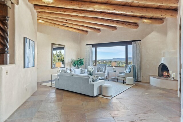 living room featuring beam ceiling, a wall mounted AC, and wooden ceiling