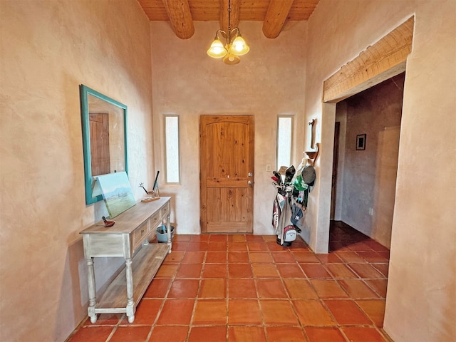 tiled foyer with wood ceiling, a notable chandelier, and vaulted ceiling with beams