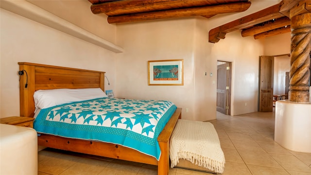 bedroom featuring a towering ceiling, beamed ceiling, and light tile patterned floors