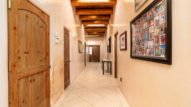 hall featuring beamed ceiling and light tile patterned flooring