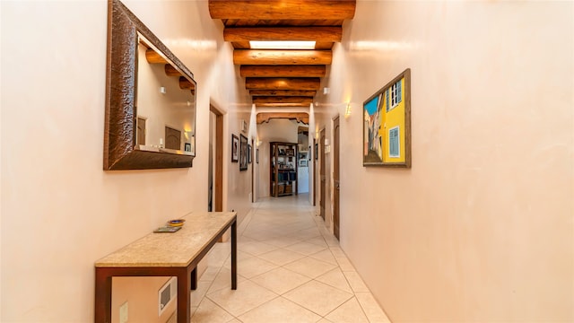 corridor featuring beam ceiling and light tile patterned flooring