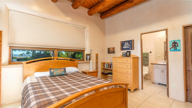 tiled bedroom featuring beam ceiling, wooden ceiling, and ensuite bath