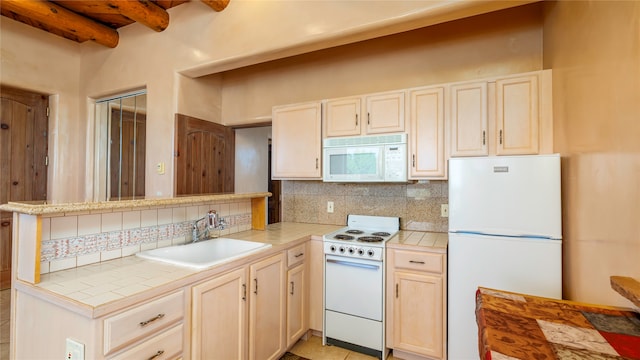 kitchen with white appliances, tile countertops, sink, and beam ceiling