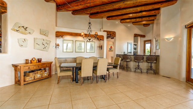 dining room with a high ceiling, beamed ceiling, and light tile patterned flooring