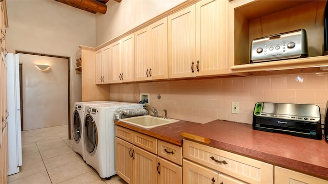 laundry room featuring light tile patterned floors, sink, and separate washer and dryer