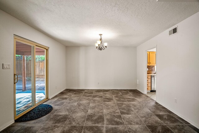 empty room featuring visible vents, baseboards, a textured ceiling, and an inviting chandelier