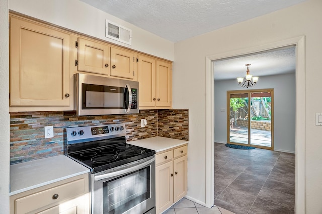 kitchen with visible vents, a notable chandelier, backsplash, stainless steel appliances, and light countertops