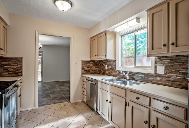 kitchen with light countertops, light tile patterned floors, decorative backsplash, appliances with stainless steel finishes, and a sink