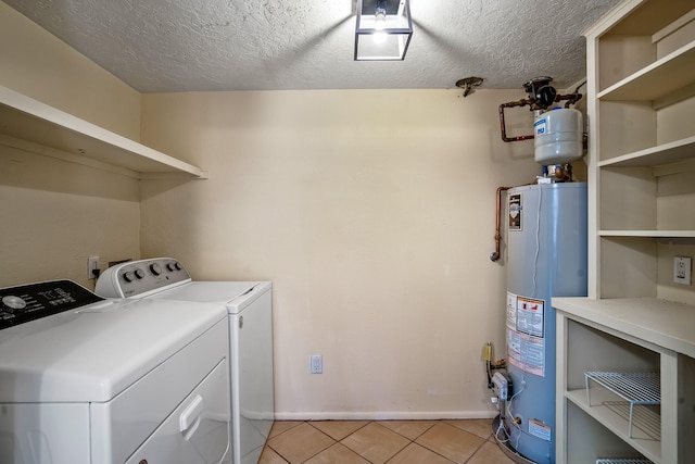 laundry room featuring water heater, laundry area, light tile patterned flooring, independent washer and dryer, and a textured ceiling