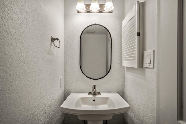 bathroom with a sink and a textured wall