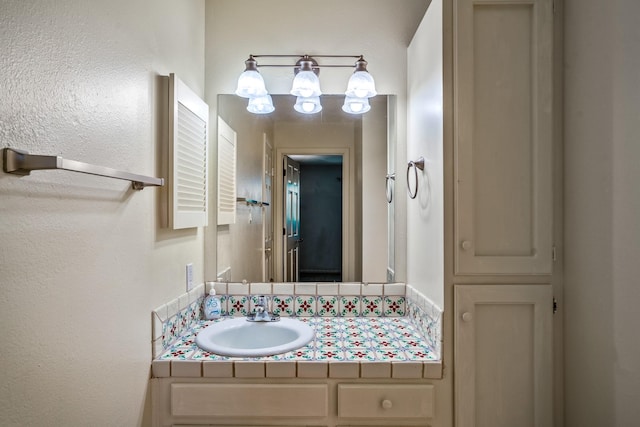 bathroom with vanity and a textured wall