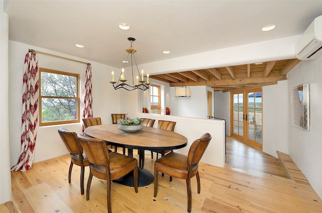 dining space featuring an inviting chandelier, light hardwood / wood-style flooring, french doors, beam ceiling, and a wall mounted air conditioner