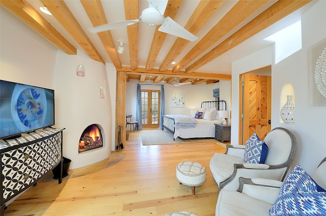 bedroom with hardwood / wood-style floors, ceiling fan, and beam ceiling