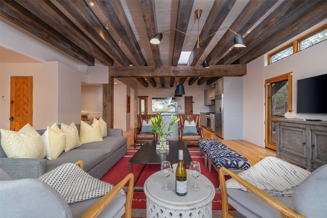 living room featuring lofted ceiling with beams and light hardwood / wood-style floors