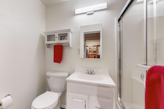 full bathroom with a shower stall, toilet, and vanity