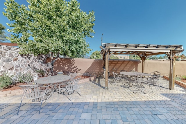 view of patio with outdoor dining area, a fenced backyard, and a pergola