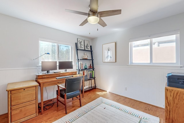 office featuring a wainscoted wall, a ceiling fan, and wood finished floors