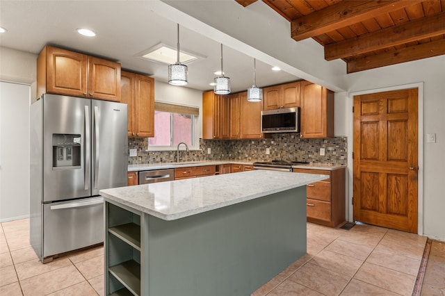 kitchen featuring hanging light fixtures, light stone counters, stainless steel appliances, a kitchen island, and tasteful backsplash