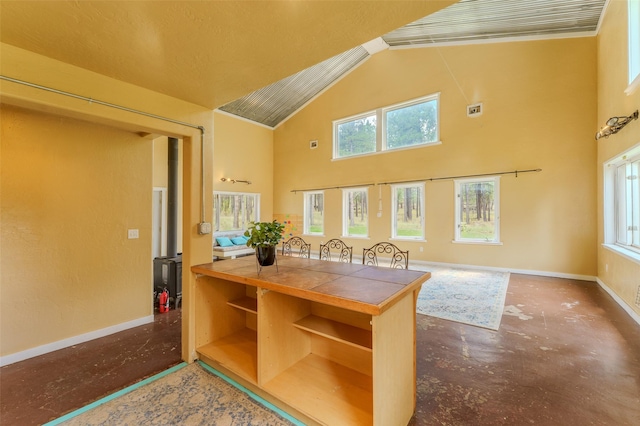 office space with a healthy amount of sunlight, concrete flooring, and high vaulted ceiling