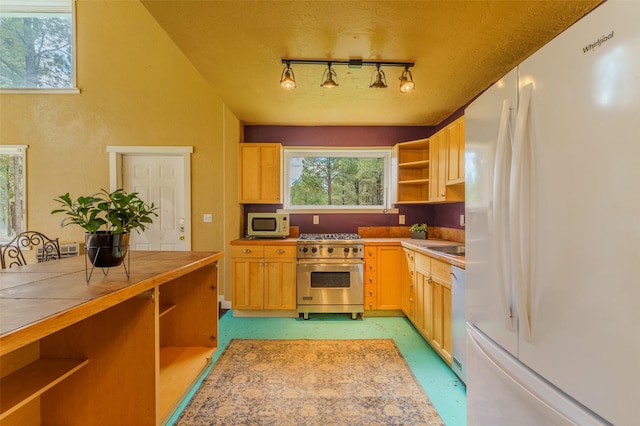 kitchen with a textured ceiling, white appliances, and rail lighting