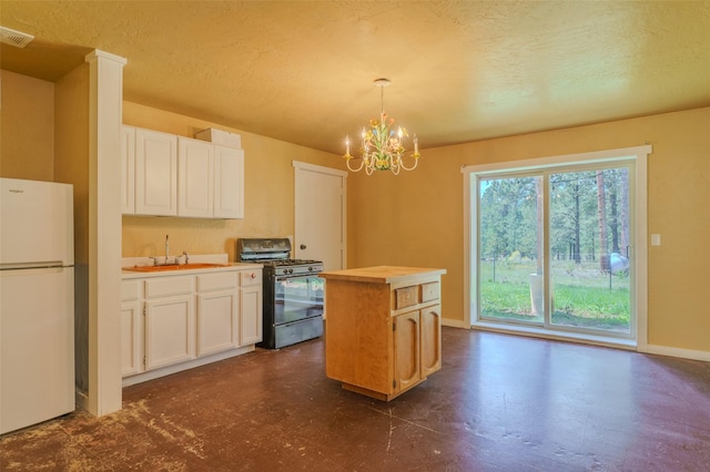 kitchen with black range with gas cooktop, sink, white refrigerator, decorative light fixtures, and a kitchen island