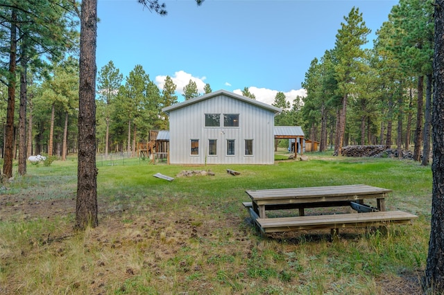 rear view of house featuring a yard and an outbuilding