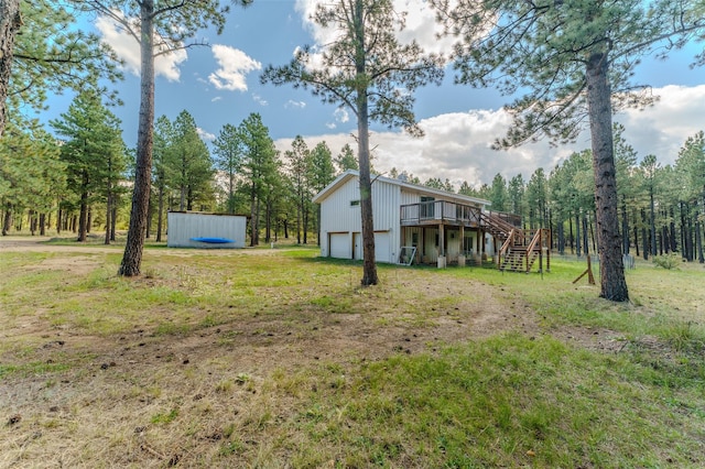 view of yard featuring a garage and a wooden deck