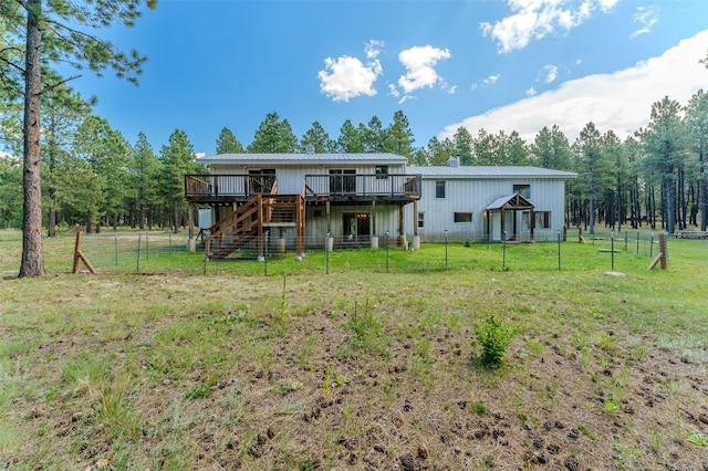 back of property featuring a yard and a wooden deck