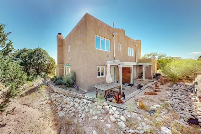 rear view of house featuring central AC unit and a patio area