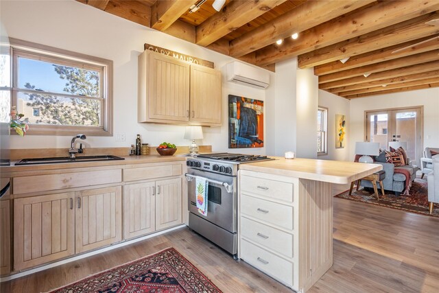 637 Alto St Unit A, Santa Fe, NM 87501 - kitchen featuring beamed ceiling, a sink, high end range, a peninsula, and an AC wall unit