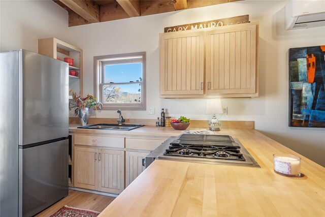 637 Alto St Unit A, Santa Fe, NM 87501 - kitchen with beamed ceiling, a sink, freestanding refrigerator, butcher block countertops, and a wall mounted air conditioner