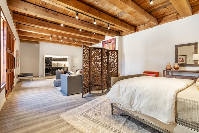 bedroom with beamed ceiling, stacked washer and dryer, wood ceiling, and light hardwood / wood-style flooring