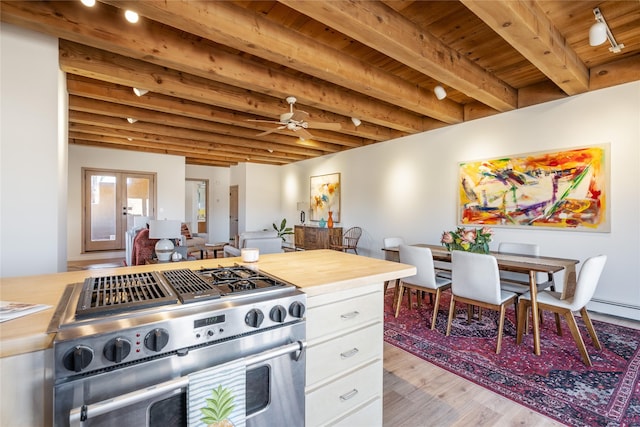 kitchen featuring beam ceiling, white cabinets, gas range, wooden ceiling, and light wood-type flooring