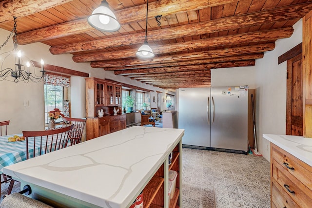 kitchen with hanging light fixtures, stainless steel refrigerator, wood ceiling, and beamed ceiling